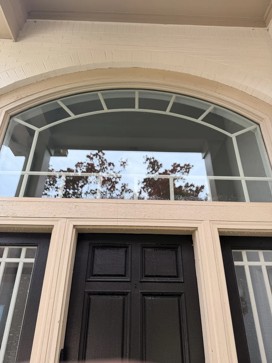 Arched front-entry transom window after professional cleaning