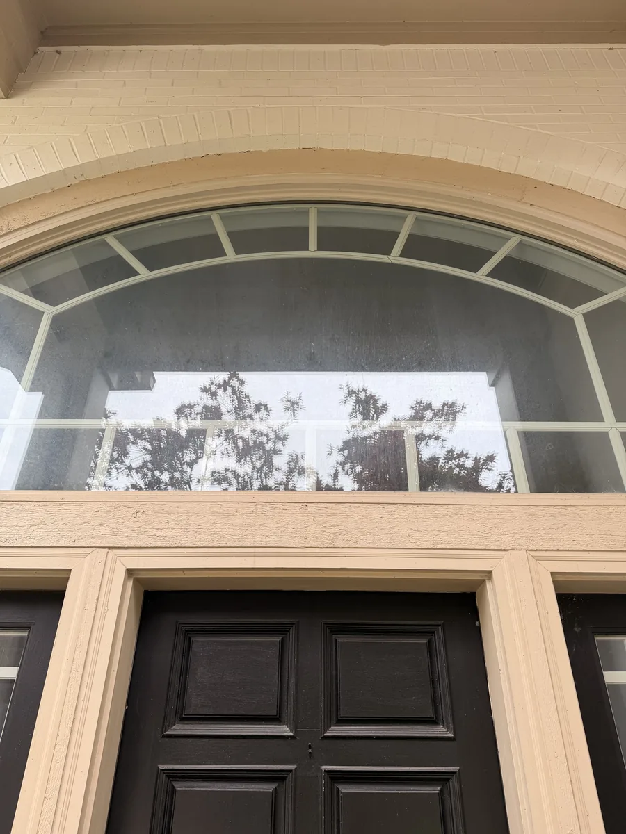 Arched front-entry transom window before cleaning in Fishers, IN
