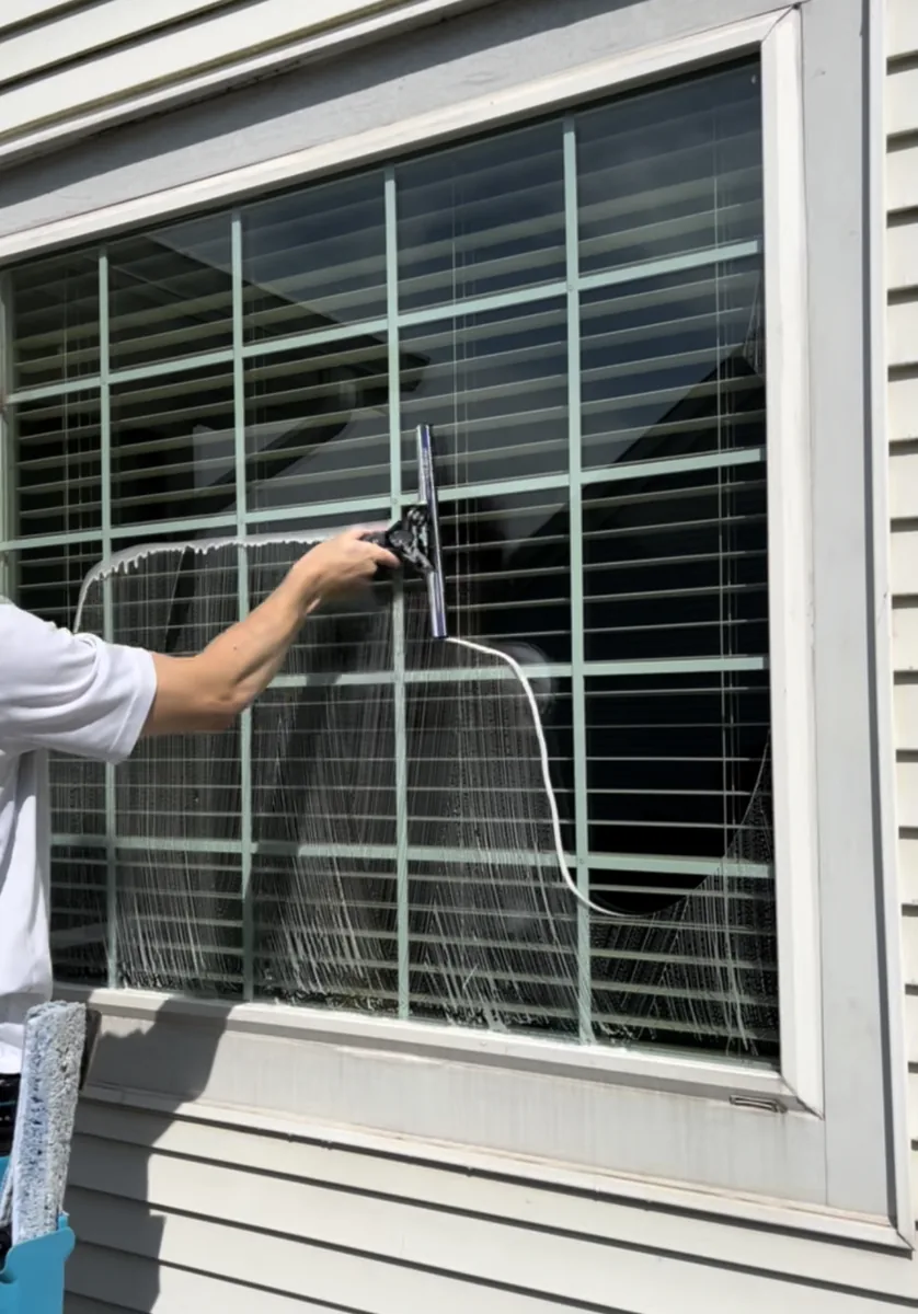 Hand-detailed residential window cleaning with a squeegee